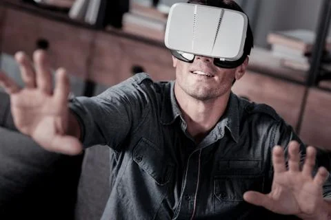 Joyful millennial guy trying on vs headset Stock Photos