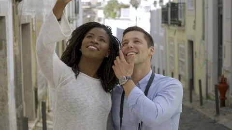 Joyful mix raced couple of tourists standing in old city street Stock-Footage 132936498