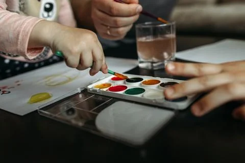 A joyful moment of creativity shared between a child and parent with waterc.. Stock Photos