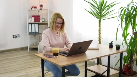 Joyful moments of remote work in a cozy home office with plants and coffee Stock Footage 308718674