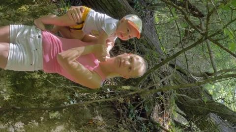Joyful Mother and Son Exploring Nature Together in the Forest During a Sunny Stock Footage 280305433