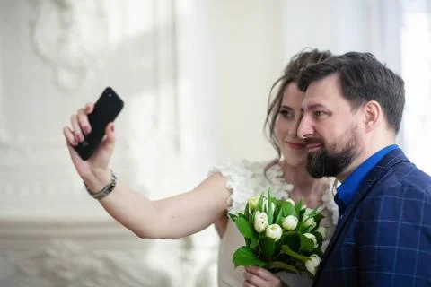 Joyful newlyweds make selfie. Lovers take pictures of themselves on the phone Foto stock