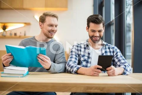 Joyful nice men reading books Stock Photos