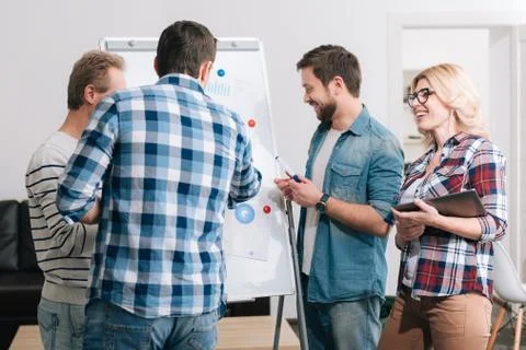 Joyful office workers standing around the whiteboard Stock Photos