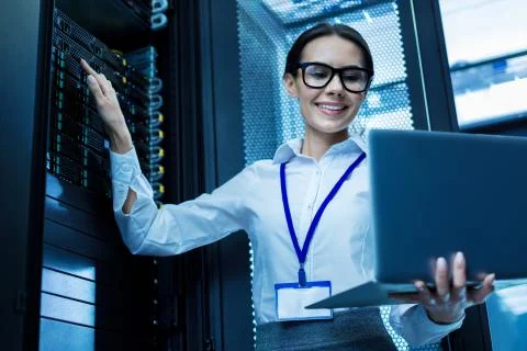 Joyful operator working in a server cabinet Stock Photos