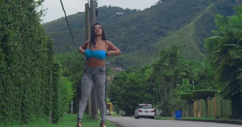 A joyful performance by a girl dancing and singing in the middle of a scenic Stock Footage 332187534