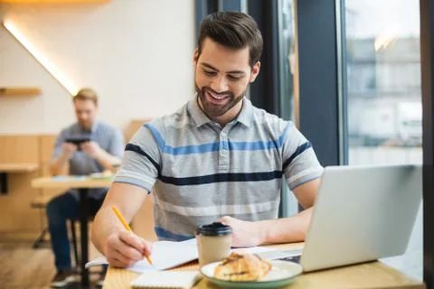 Joyful positive man taking notes Stock Photos