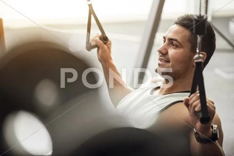 Joyful positive man working out in a gym Stock Photos