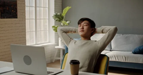 Joyful remote worker laid back on his chair. Positive asian male student happy Video stock 127306611