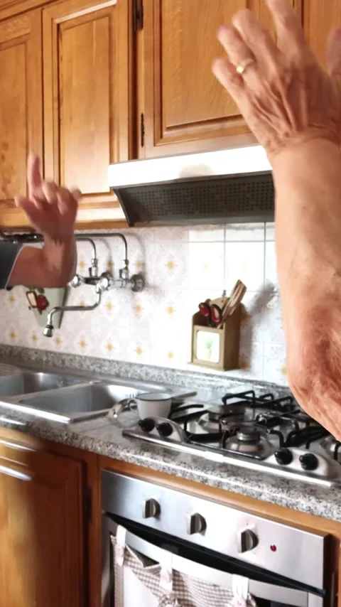 Joyful senior couple energetically dancing together inside their home kitchen Stock Footage 344396108
