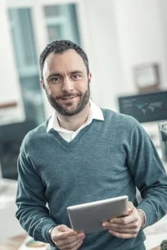 Joyful smart adult engineer using a tablet Stock Photos