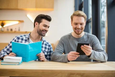 Joyful smart man using an electronic reader Stock-Fotos