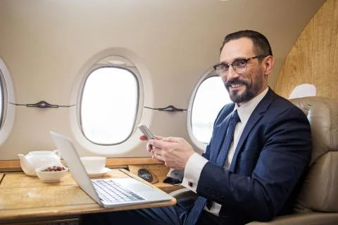 Joyful solid man enjoying his flight Stock Photos