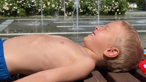 Joyful Splash: Young Boy Delights in Simferopol Fountain on Sunny Day Video stock 311111023
