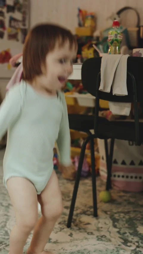Joyful toddler energetically dancing and jumping in colorful outfit, Happy Stock Footage 311247046