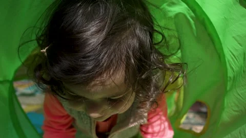 Joyful Toddler Playing Inside a Green Tunnel, Close-up Stock Footage 306732216