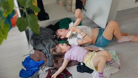 Joyful tween sister singing loudly on floor near a little kid. Stock Footage 336713059