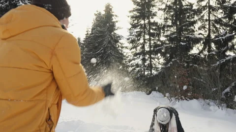 Joyful winter scene with friends playing in fresh snow, surrounded by tall Stock-Footage 341039944