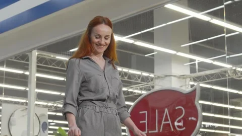 Joyful woman beaming at the camera while holding colorful shopping bags Stock Footage 311946611