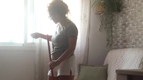 Joyful woman having fun while cleaning the house, dancing and singing Stock Footage 344249944