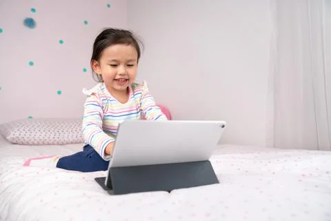 Joyful young child using digital tablet. Stock Photos
