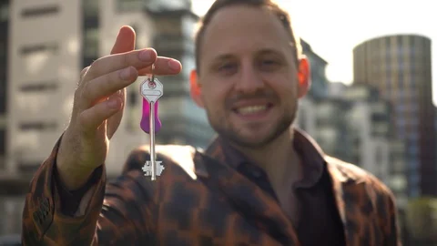 A joyful young man shows the keys to the apartment. Stock Footage 130141162