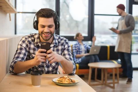 Joyful young man using his smartphone Stockfoto's