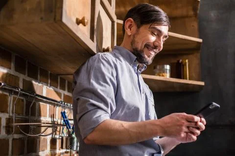 Joyful young man using his smartphone Stock Photos