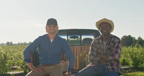 Joyfull men posing in sunlight at harvest plantation. Two farmers sitting at Stock Footage 254096732