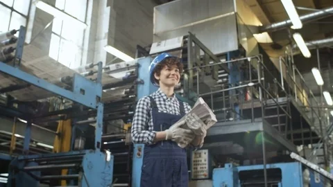Joyous Female Technician Posing with Newspapers in Printing Plant Stock Footage 98934959