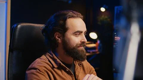 Joyous IT admin looking at PC screen, pleased after solving script errors Stock Photos