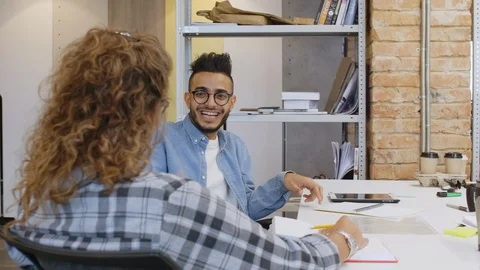 Joyous Middle Eastern Man Talking and Giving High Five to Female Colleague Stock Footage 126136073