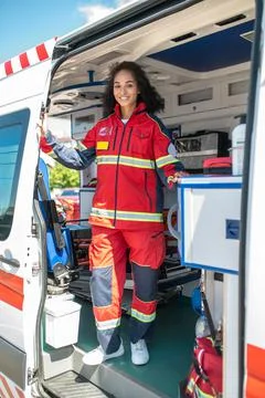 Joyous paramedic posing for the camera in the ambulance car Foto stock