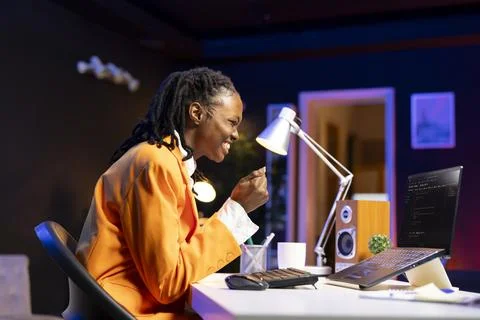 Joyous programmer typing code on laptop, delighted after implementing features Stock Photos