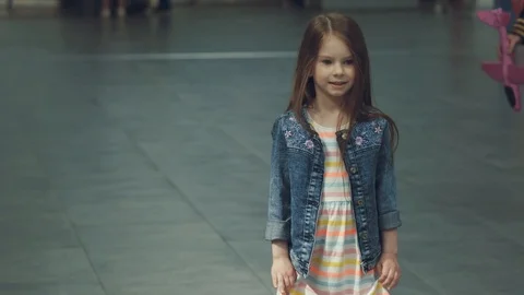 Joyous smiling pilot presenting toy pink plane to a little cute girl in terminal Stock Footage 108868669