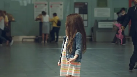 Joyous smiling pilot presenting toy pink plane to a little cute girl in terminal Stock Footage 108868701