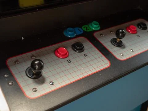 Joystick and button controls of classic arcade cabinet in dark arcade Stock Photos