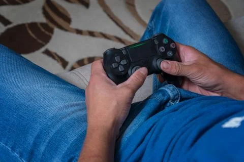 The joystick of the console is close-up in the hands of a man. Man playing on Stock Photos