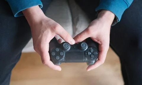 Joystick for game console in the mans hands.The concept of leisure and Stock Photos