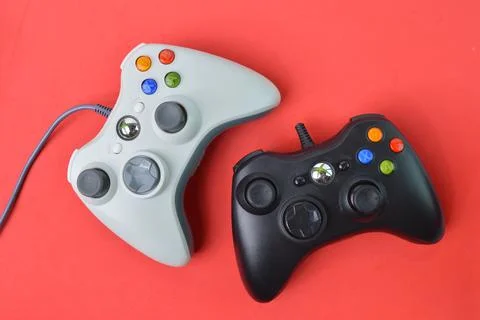 Joystick game controllers over red background. Stock Photos