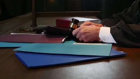 Judge hand opening folder on stand in court room Stock Footage 73588792