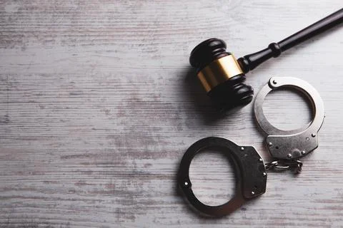 Judge's hammer and handcuffs on the table Stock Photos