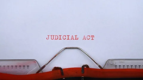 Judicial act - phrase printed on an old typewriter in red letters, close up. Stock Footage 128400714