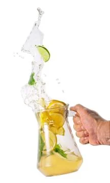 Jug with lemonade splash in hand Stock Photos