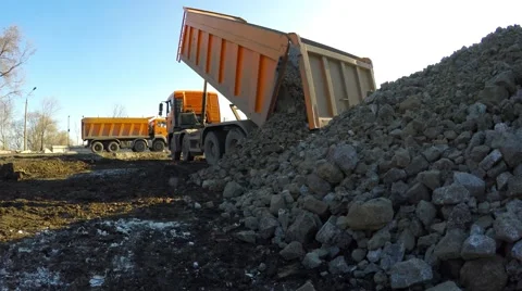 Juggernaut unloads stones. In the background, the second truck. 库存影片 58579363