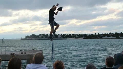 Juggler on unicycle does hat trick off one foot Stock Footage 20585405