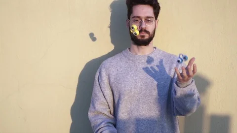 Juggler, Young Man Juggling with three funny eyes toys, in Slow Motion video  Stock Footage 106722176