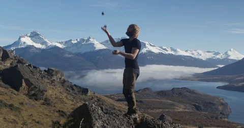 Juggling rocks at summit with panoramic view Stock Footage 90405062