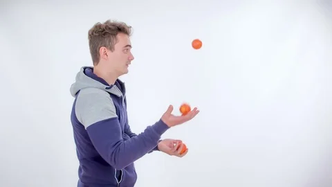 Juggling with three tangerines Stock Footage 83724655