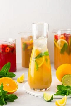 Jugs of refreshing fruit drinks with fruit wedges Stock Photos